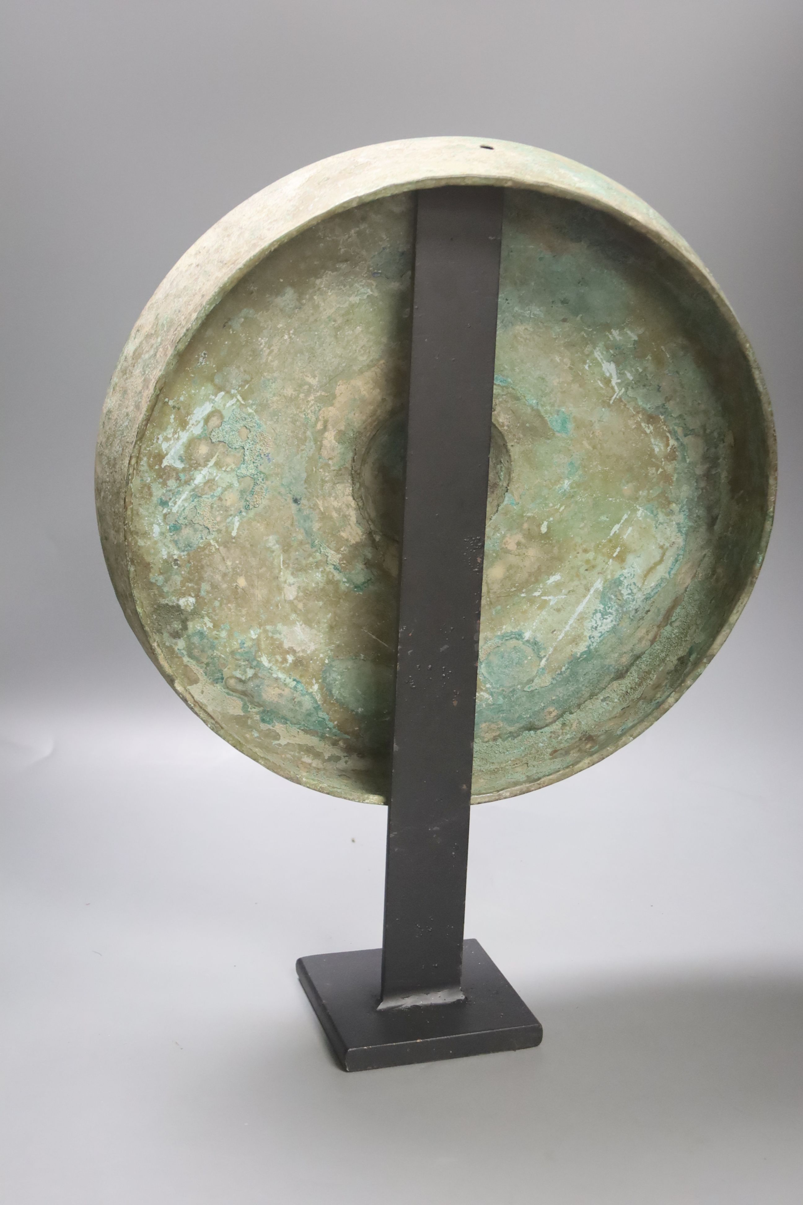 A Cambodian bronze gong, Khmer 12th/13th century, later metal stand 33cm diam